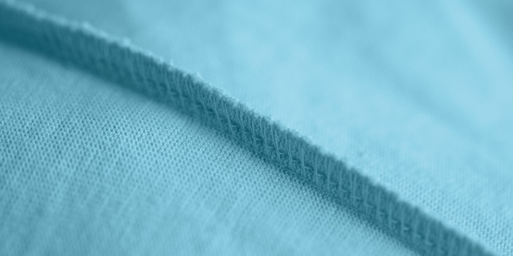 Nahaufnahme einer Überwendlichnaht auf einem blauen Stoff